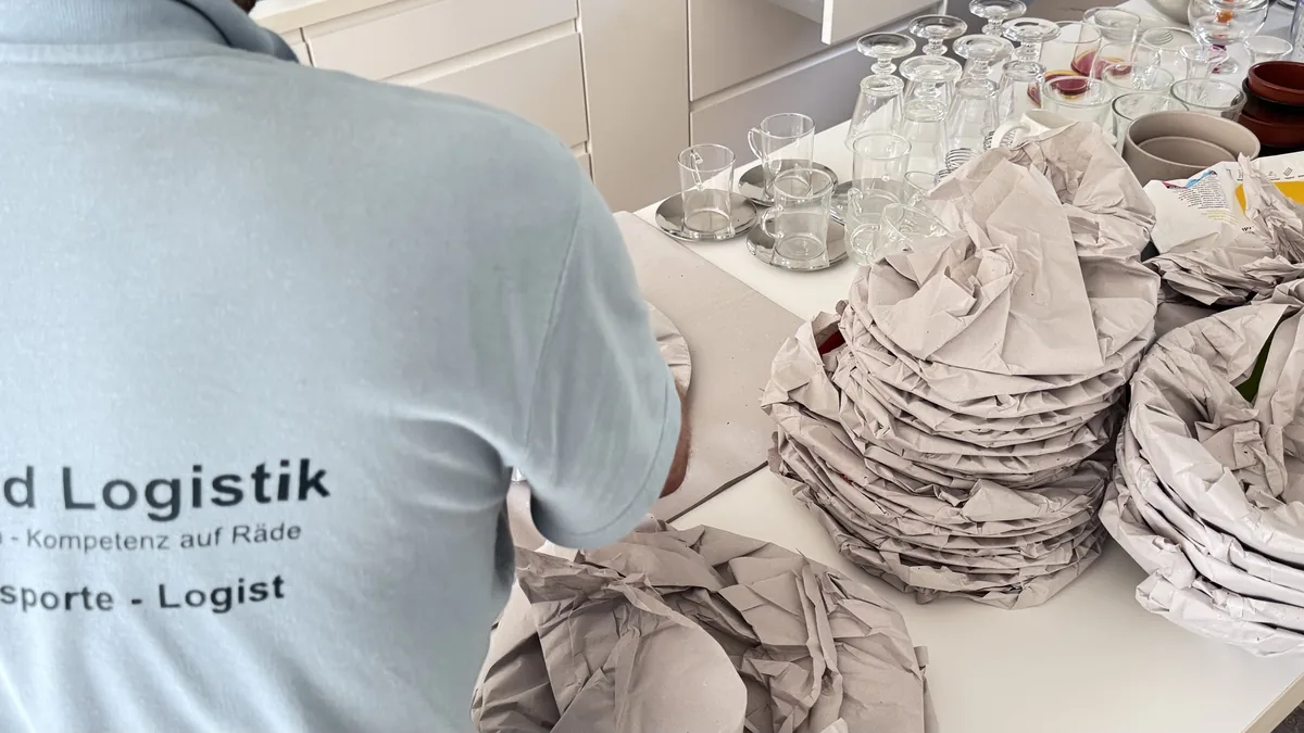 Rheinland-Logistik-Mitarbeiter beim Einpacken von Tellern und Gläsern