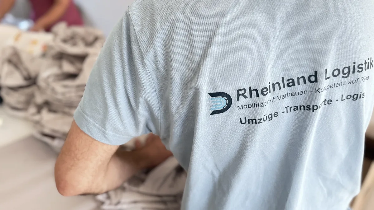 Mitarbeiter im Rheinland-Logistik-Shirt bei der Verpackungsarbeit